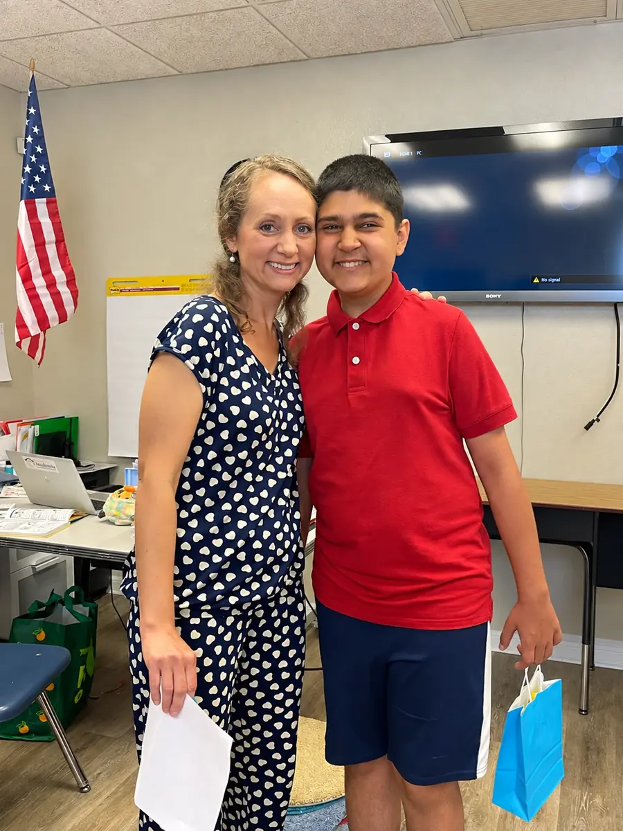 Olga with her son, both smiling, in a classroom